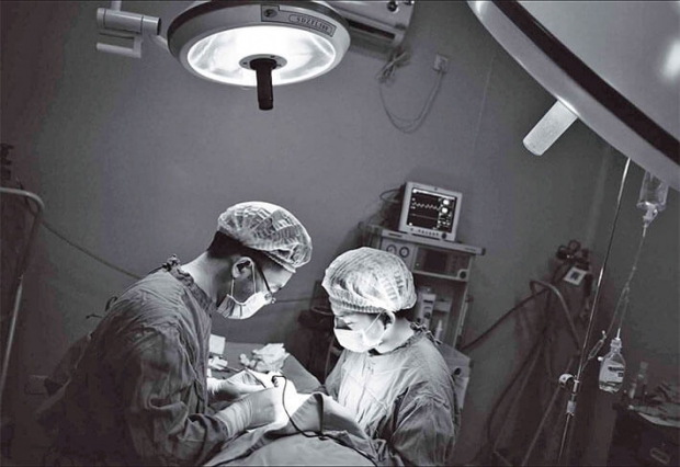 2013년 8월 9일 의사 2명이 중국 남서부 충칭(重慶)시에서 수술을 집도하고 있다. | PETER PARKS/AFP/GETTY IMAGES
