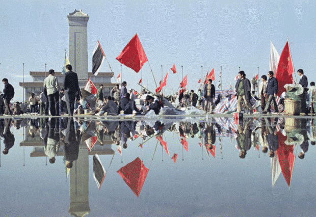 1989년 5월 24일 밤새 내린 비로 젖은 길 위로 베이징 톈안먼 광장에서 열리는 아침 활동이 반사되어 보인다. 뒤로 보이는 인민영웅기념비 너머에 마오쩌둥 기념당이 위치하고 있다. | AP Photo/Mark Avery