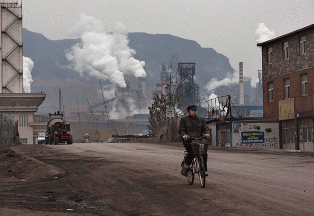 중국인 노동자가 허베이성의 철강 공장을 지나가고 있는 모습. | Kevin Frayer/Getty Images