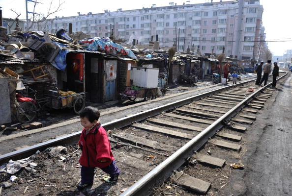 2009년 3월 11일 중국 랴오닝성 선양의 판자촌 마을에서 어린이가 철도를 따라 노는 모습. 이 지역 주민들은 정부가 제공한 저소득 임대아파트로 이주할 계획이었다. | China Photos/Getty Images