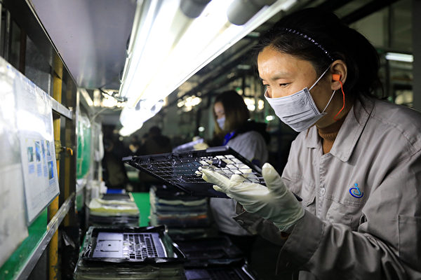 중국 안후이성 루안시에 위치한 한영 오토 산업단지의 공장에서 노트북 부품 점검 중인 근로자들의 모습. 이 공장은 도시바(Toshiba), 마츠시타(Matsushita) 그리고 여러 세계적 브랜드의 부품 및 장비를 생산한다. | STR/AFP/Getty Images
