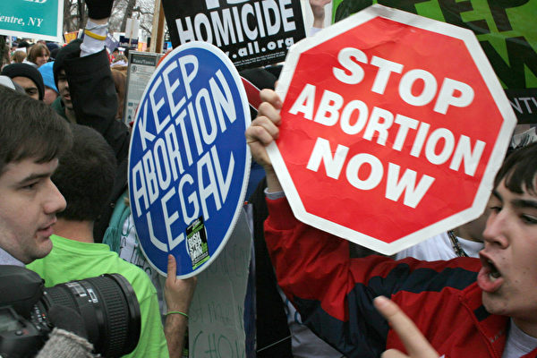 2006년 1월 23일, 낙태에 대한 대법원 판결 33주년을 기념하여 수만 명의 낙태 찬성 및 반대자들이 워싱턴 DC에서 집회를 열고 있는 가운데, 낙태 찬성 시위대(왼쪽)와 낙태 반대 시위대(오른쪽)가 대치하고 있다. 낙태는 1973년 1월 22일 로 대 웨이드 대법원 판결 이후 미국에서 합법적이다. | Photo credit should read KAREN BLEIER/AFP/Getty Images