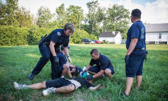 오하이오주 데이튼의 드렉셀 인근 지역에서 현지 경찰과 구급대원들이 약물 과다 복용 남성을 돕고 있다. 무엇을 과다 복용했는지는 불분명하다. 2017. 8. 3. | Benjamin Chasteen/The Epoch Times



