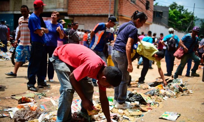 베네수엘라 수도 카라카스의 엘발에 소재한 약탈당한 슈퍼마켓 밖에서 사람들이 먹을 것을 찾고 있다. 2017. 4. 21. | Ronaldo Schemidt/AFP/Getty Images