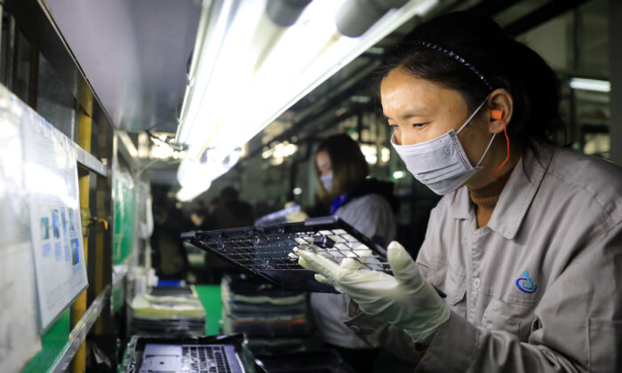 중국 안후이성 루안시의 산업단지 내 공장에서 한 근로자가 노트북 부품 점검하고 있다. | STR/AFP=연합뉴스