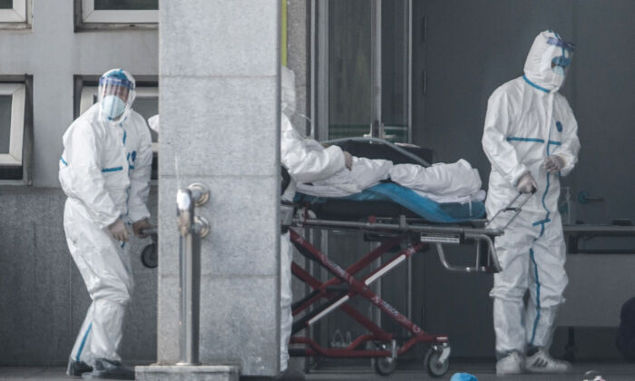 중국 중부 후베이성 우한에서 의료진이 사스 바이러스성 폐렴에 걸린 환자를 진인탄 병원으로 옮기고 있다. 2020. 1. 18. | STR/AFP via Getty Images