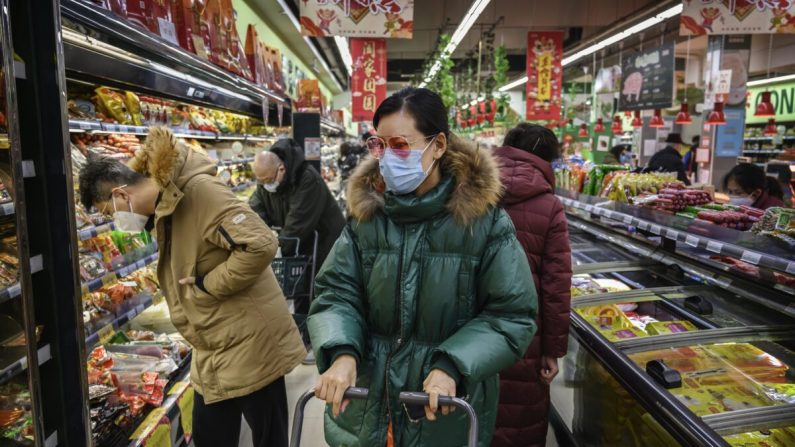 한 중국 여성이 마스크와 선글라스를 착용한 채 베이징의 슈퍼마켓에서 식료품을 사고 있다. 2020년 1월 28일 | Kevin Frayer/Getty Images