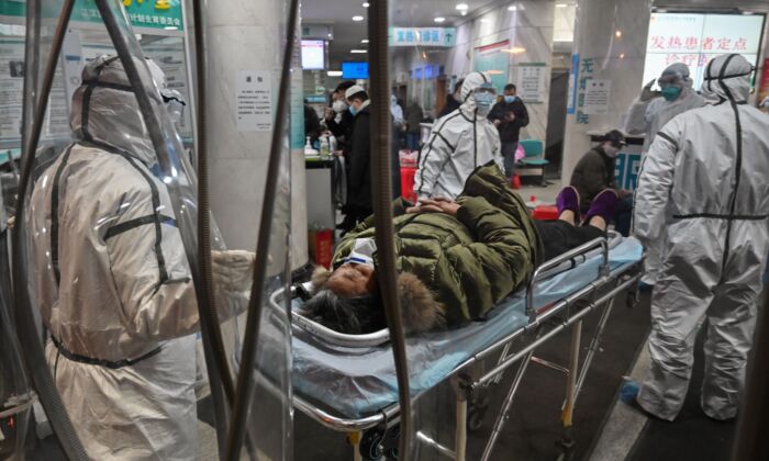 보호복을 입은 의료진이 중국 우한 적십자병원에 환자와 함께 있다. 2020. 1. 25. | Hector Retamal/AFP via Getty Images