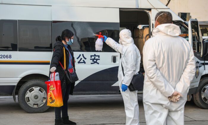 병원에서 나와 중국 중부 후베이성 신종 코로나바이러스 발원지 우한 검역구역에 다시 들어가는 환자에게 의료진이 소독약을 뿌리는 모습. 2020. 2. 3. | STR/AFP via Getty Images