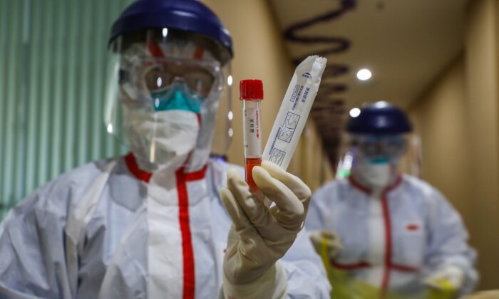 중국 우한 한 검역구역에서 신종 코로나바이러스 검사 대상자의 샘플을 채취해 시험관을 보여주는 의료진. 2020. 2. 4. | STR/AFP via Getty Images