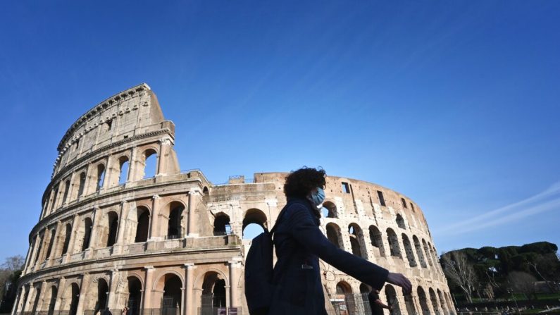 신종 코로나 바이러스 감염증에 대비해 마스크를 쓴 관광객이 이탈리아 로마의 콜로세움 경기장 유적을 지나고 있다. 2020.3.10 | ALBERTO PIZZOLI/AFP via Getty Images
