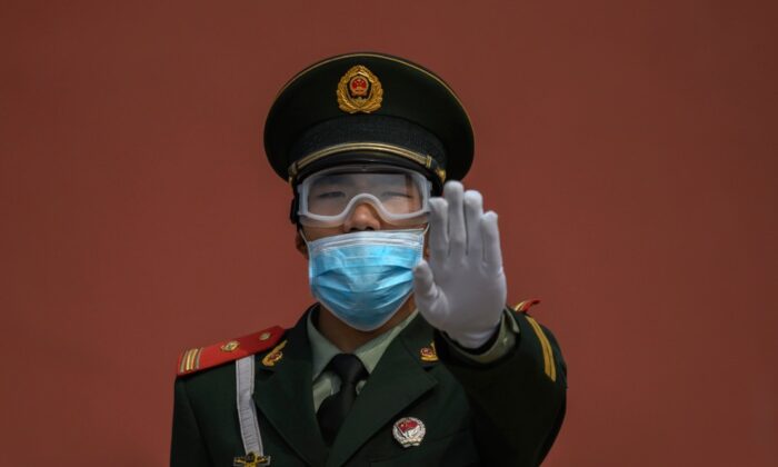 방문객 제한을 조건으로 재개장한 중국 베이징 자금성 입구에서 마스크를 한 중국 경찰이 수신호하고 있다. 2020. 5. 1. | Kevin Frayer/Getty Images