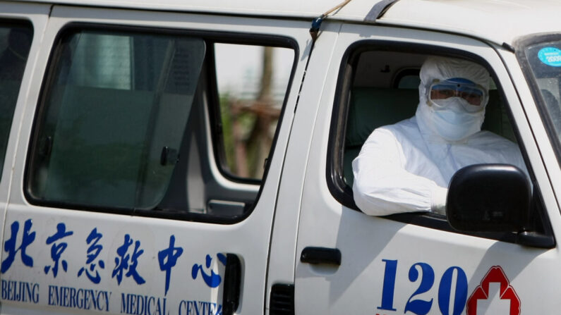 베이징의 한 병원 근무자가 전신 방호복을 입고 병원 차량에 탑승해 있다. | Feng Li/Getty Images