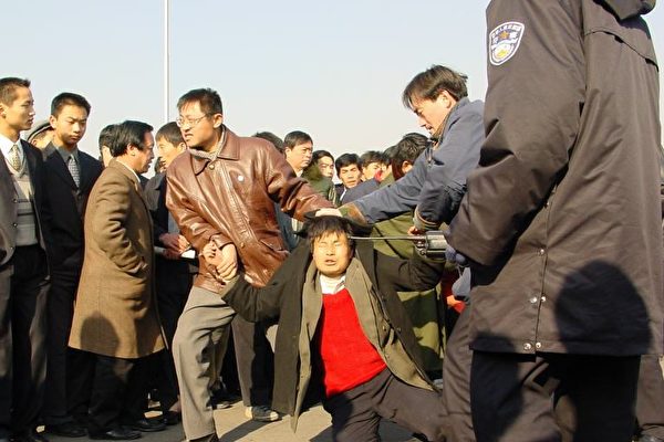 중국 베이징 텐안먼 광장에서 시민들에게 파룬궁에 관한 진실을 알리던 파룬궁 수련자(가운데 붉은 상의)가 사복 차림 공안들에게 체포되고 있다. | 밍후이왕