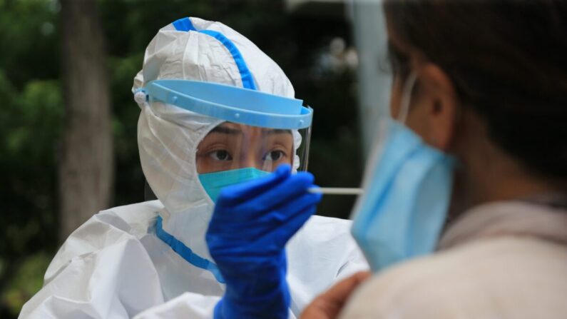 2020년 7월 26일, 중국 랴오닝성 다롄(大連)시에서 보건당국 직원이 우한폐렴 진단 테스트를 하고 있다. | STR/AFP via Getty Images