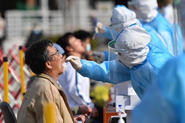 지난 10월 12일 중국 동부 산둥성 칭다오에서 의료진이 시민들을 대상으로 중공 바이러스 감염증(코로나19) 검진을 위한 구강 샘플을 채취하고 있다. | STR/AFP via Getty Images