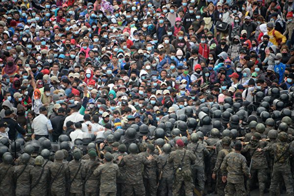 지난 1월 17일(현지시각) 과테말라로 진입하려는 온두라스 난민 수천명이 수비병력을 밀치고 있다. 과테말라 경찰은 최루탄을 발사하며 이들을 진압했다. | OHAN ORDONEZ/AFP via Getty Images