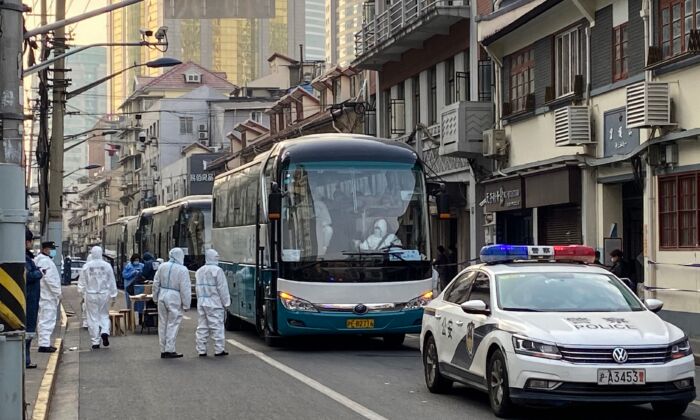 경찰과 직원들이 상하이 황푸 지구 한 마을의 모든 주민을 격리센터로 이동시키기 위해 버스를 배치하고 있다. 2021. 1. 21. | AFP via Getty Images