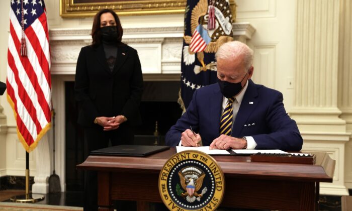 조 바이든 대통령이 카말라 해리스 부통령이 지켜 보는 가운데 행정 명령에 서명하고 있다. | Alex Wong / Getty Images