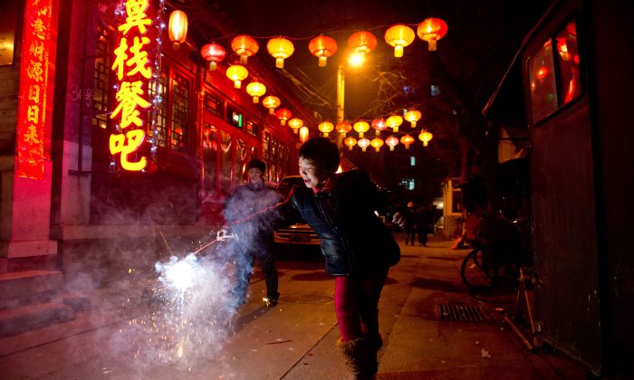 설을 맞아 등불 축제 기간 베이징 골목에서 폭죽을 들고있는 소녀. | Ed Jones/AFP/Getty Images
