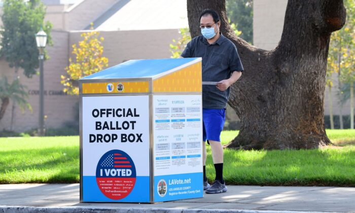 캘리포니아주 몬트레이 파크에 설치된 드롭박스에 투표지를 넣고 있는 유권자. 2020.10.5 | Frederic J. Brown/AFP via Getty Images