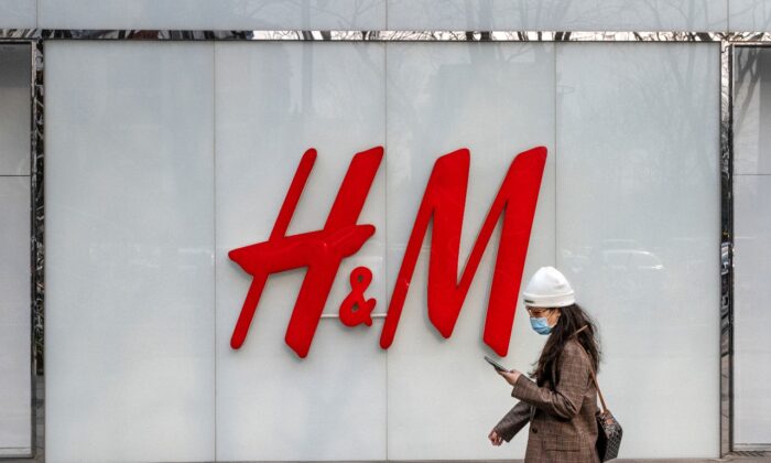지난 3월 25일 중국 베이징의 한 쇼핑가에서 한 여성이 의류 브랜드 H&M의 플래그십 스토어를 지나가고 있다. | Kevin Frayer/Getty Images