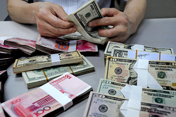 한 은행원이 중국 위안화와 달러를 세고 있다. | VCG/VCG via Getty Images