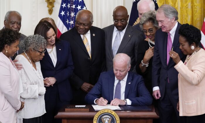 17일(현지시간) 조 바이든 미국 대통령(가운데)이 노예해방일을 연방공휴일로 지정하는 법에 서명하고 있다. | van Vucci/AP Photo/ 연합