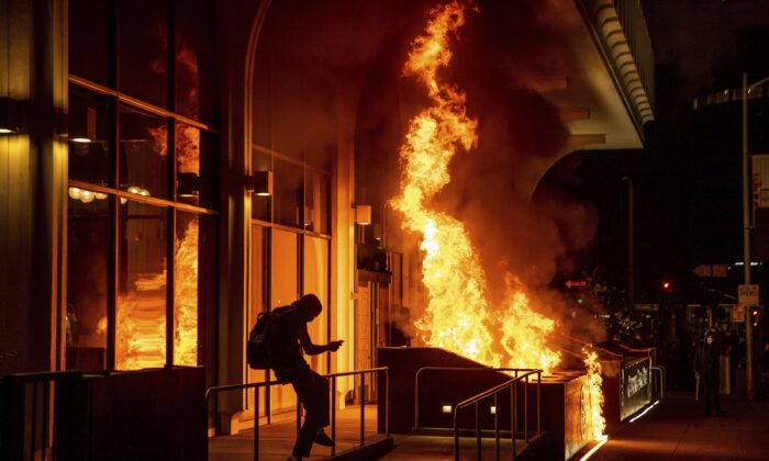 지난 4월 미국 캘리포니아주 오클랜드에서 시위대가 ‘캘리포니아 뱅크 앤 트러스트’ 건물에 불을 붙였다. | Ethan Swope/AP Photo/ 연합