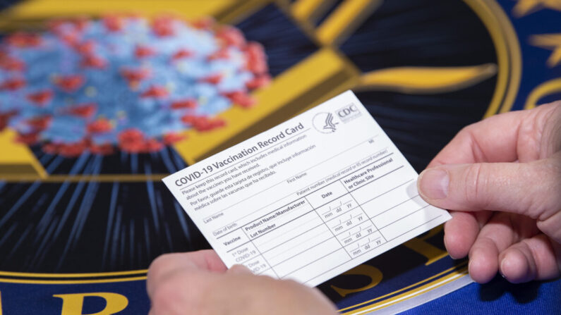 미 보건부 직원이 질병통제예방센터(CDC)에서 발급하는 코로나19 백신 접종 카드를 들고 있다. 카드는 아직 아무런 기록이 찍히지 않은 새 것이다. | |DoD photo by EJ Hersom