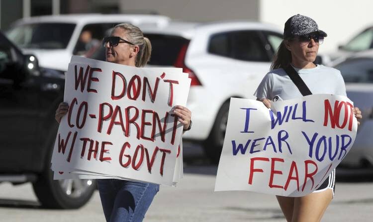 교내 마스크 착용 의무화에 반대하는 플로리다 주민들이 팻말을 들고 거리 시위를 하고 있다. | my Beth Bennett/South Florida Sun-Sentinel via AP/연합