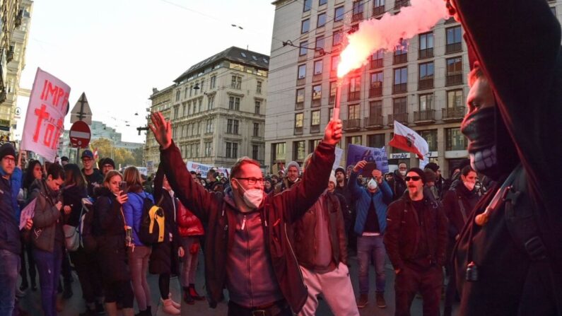 20일 오스트리아 수도 빈에서 중공 바이러스(코로나19) 백신 의무화와 봉쇄령에 반대하는 시민들이 조명탄에 불을 밝히며 항의하고 있다. | JOE KLAMAR/AFP via Getty Images/연합