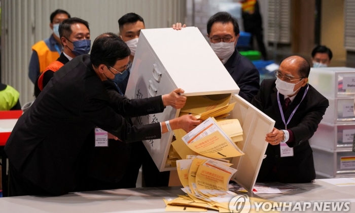홍콩 입법회 선거 투·개표일인 12월 19일 바르나바스 펑과 선관위원장과 위원들이 홍콩의 한 개표소에서 투표함을 열고 있다. | 연합뉴스