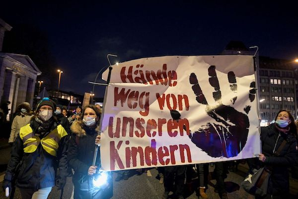 독일 함부르크에서 아동 백신 접종 의무화에 반대하는 시위대가 '우리 아이들에게서 손 떼라'라고 쓴 현수막을 들고 행진하고 있다. | 로이터/연합