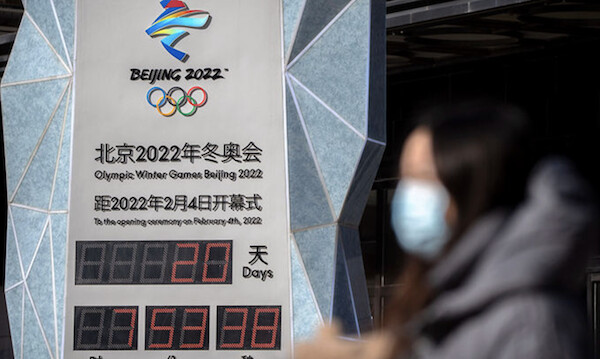 지난 15일 중국 베이징에서 마스크를 쓴 한 여성이 2022 베이징 동계올림픽 카운트다운 시계 앞을 지나가고 있다. | AP/연합