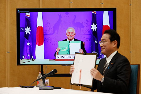 기시다 후미오 일본 총리(우)와 스콧 모리슨 호주 총리가 6일 '공동훈련 등을 위한 원활화 협정(RAA)'에 서명한 뒤 들어 보이고 있다. | ISSEI KATO/POOL/AFP via Getty Images/연합