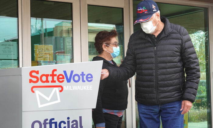 지난 2020년 10월 20일 조기 투표에 참여한 위스콘신주 유권자가 부재자 투표함에 투표지를 넣고 있다. | Scott Olson/Getty Images