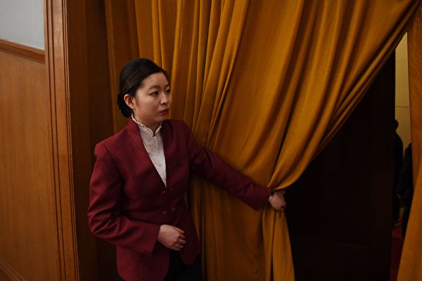 2018년 3월 베이징에서 열린 중국 공산당 정치협상 회의에서 한 여직원이 회의장 막을 열고 있다.  | GREG BAKER/AFP via Getty Images