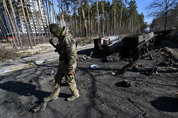 우크라이나 군인이 12일 기예프 북쪽 이르핀에서 파괴된 러시아 장갑차 잔해를 살펴보고 있다. | Sergei SUPINSKY/AFP/연합