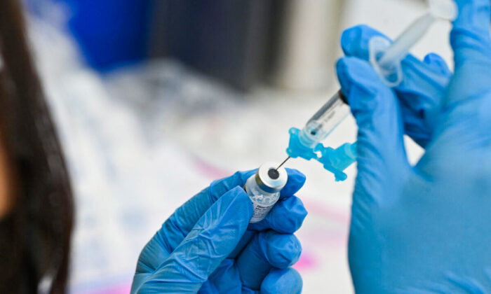의료 종사자가 화이자의 코로나-19 백신으로 주사기를 들고있다.|Robyn Beck/AFP via Getty Images