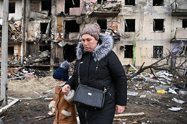 키이우 주민들이 러시아군에 의해 파괴된 아파트 앞을 지나고 있다 | Daniel Leal /AFP via Getty Images
