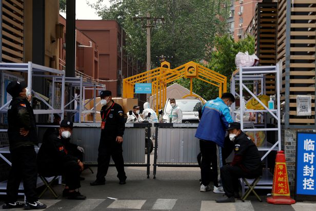 코로나19 때문에 봉쇄된 중국 수도 베이징의 한 아파트 단지 입구를 보안요원들이 지키고 있다. | 연합