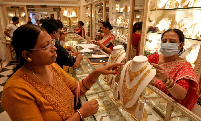 2022년 5월 3일 인도 콜카타에서 '악샤야 트리티야' 축제를 맞아, 한 고객이 보석 전시장에서 금목걸이 구매를 상담하고 있다. 인도에서는 이 축제일에 여성이 금을 구매하면 부와 가정의 평안을 얻을 수 있다고 알려져 있다. | REUTERS/Rupak De Chowdhuri=연합뉴스