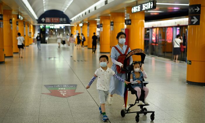 베이징의 한 지하철역에서 여성이 두 자녀와 함께 역을 걷고 있다. 2022.7.5 | AFP=연합뉴스 