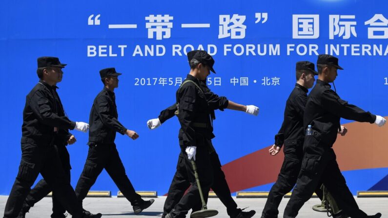 중국 베이징에 있는 국제 일대일로 협력 포럼 행사장에서 보안요원들이 일대일로 포럼 광고판을 지나가고 있다. 이 행사는 2017년 5월 14~15일 열렸다. 2017.5.13 | WANG ZHAO/AFP via Getty Images=연합뉴스 