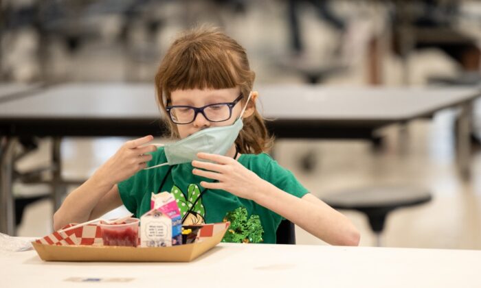 2021.03.17 켄터키주 루이빌에 있는 메도라 초등학교 구내식당에서 급식을 먹은 후 마스크를 쓰고 있는 어린이 | Jon Cherry/Getty Images