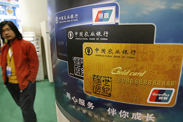 베이징 국제 금융박람회장에 전시된 중국 은행카드 광고판앞을 한 여성이 지나고 있다. | TEH ENG KOON/AFP via Getty Images=연합뉴스