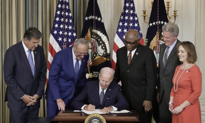 조 바이든 미국 대통령이 2022년 8월 16일 워싱턴 백악관에서 민주당 의원들이 지켜보는 가운데 인플레이션 감축 법안에 서명하고 있다. |Drew Angerer/Getty Images