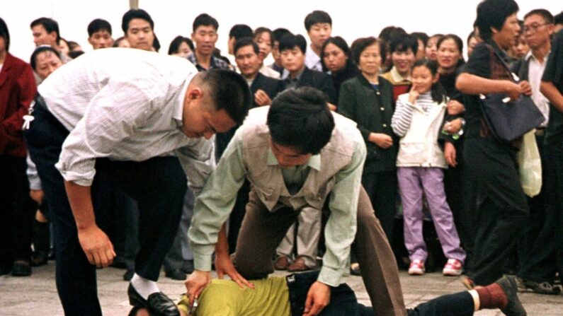 중국 사복경찰에 베이징 톈안먼 광장에서 파룬궁 탄압이 부당함을 알린 파룬궁 수련자를 바닥에 쓰러뜨려 제압하고 있다. 200.10.1 | Chien-min Chung/AP=연합뉴스