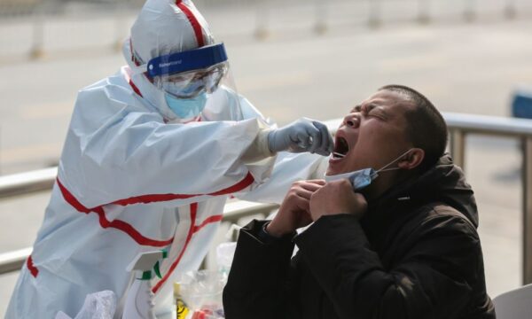 2020년 3월 5일 중국 중부 후베이성 우한시의 한 주택가에서 의료진이 코로나19 핵산 검사를 위해 한 남성으로부터 샘플을 채취하고 있다. | STR/AFP via Getty Images